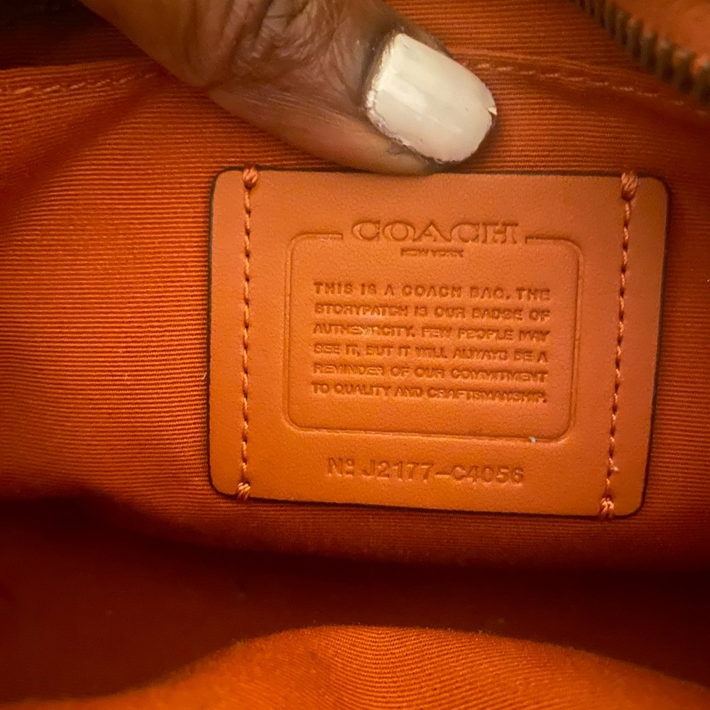 Gently used tangerine color Coach shoulder bag.